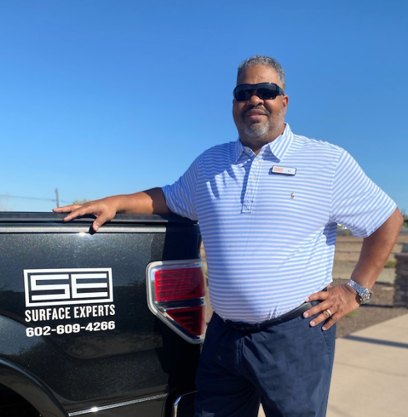 Surface Experts Phoenix owner, Ed Lennon, by his car with a Surface Experts Logo
